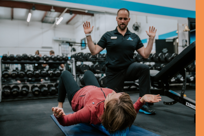 Professional fitness coach displays proper form to a client