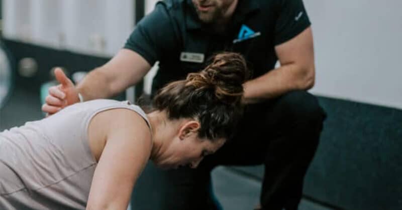 AFS trainer helping a memebr with planks